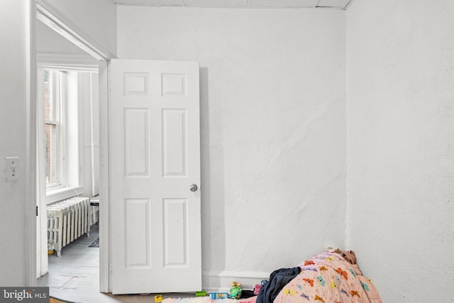 unfurnished bedroom featuring hardwood / wood-style floors and radiator