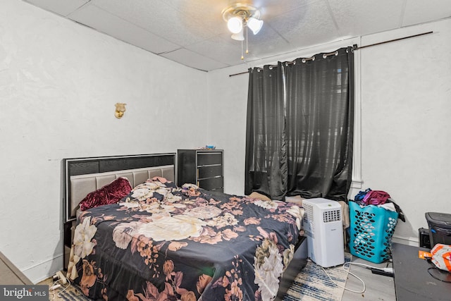 bedroom with ceiling fan and a paneled ceiling