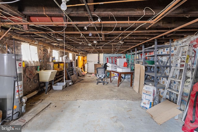 basement featuring gas water heater and sink