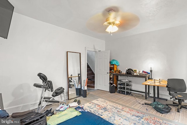 workout area with ceiling fan and light hardwood / wood-style floors