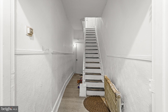 stairs featuring hardwood / wood-style floors