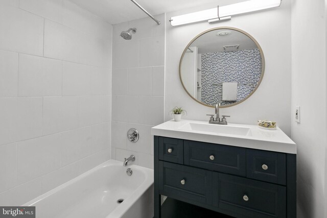 bathroom with tiled shower / bath and vanity