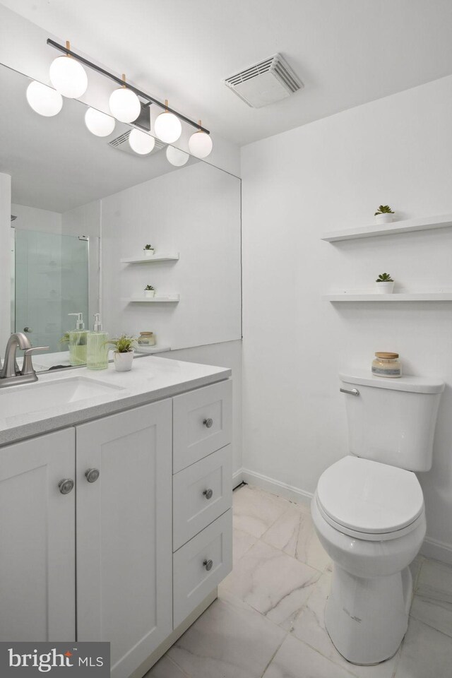 bathroom with toilet, walk in shower, and vanity