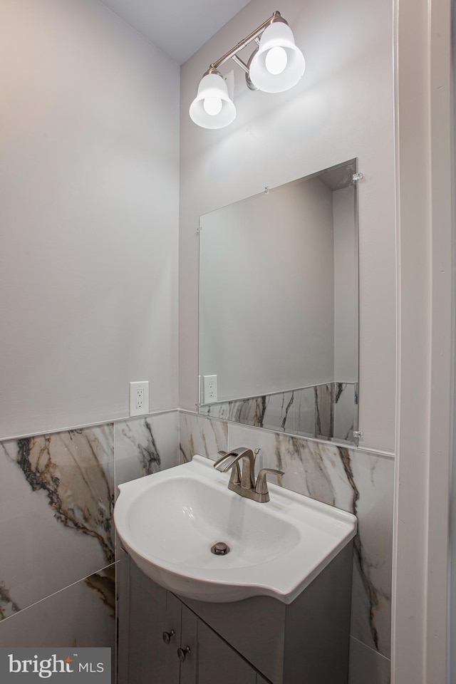 bathroom with vanity and tile walls