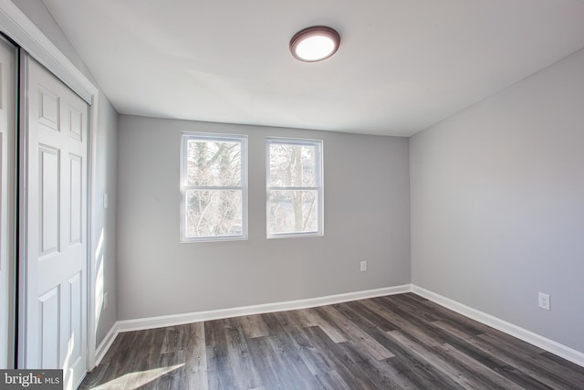 unfurnished bedroom featuring dark wood-type flooring and a closet