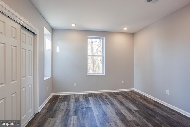 unfurnished bedroom with dark hardwood / wood-style flooring and a closet