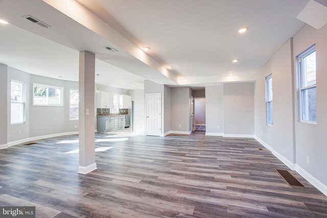 unfurnished living room with a healthy amount of sunlight and hardwood / wood-style floors