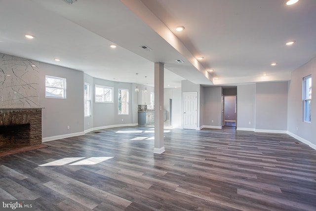 basement featuring a stone fireplace and dark hardwood / wood-style floors