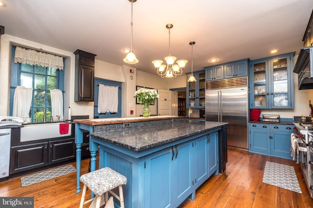 kitchen with stainless steel appliances, blue cabinetry, and decorative light fixtures