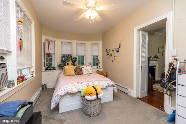 bedroom featuring dark colored carpet, a baseboard heating unit, and ceiling fan