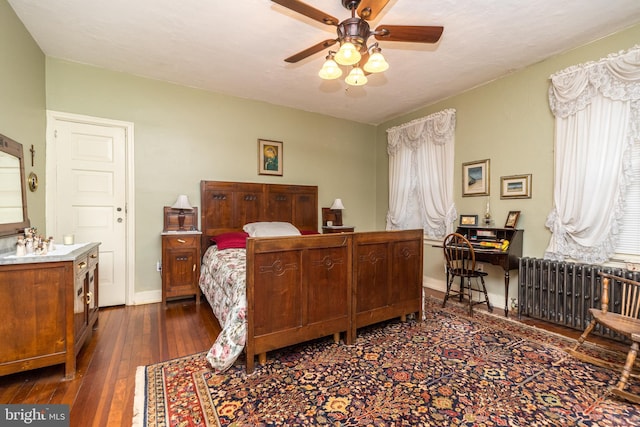 bedroom featuring dark wood-type flooring, radiator heating unit, and ceiling fan