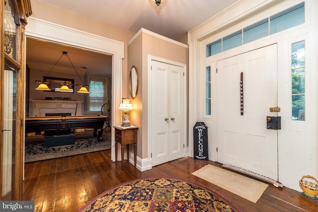 entryway with crown molding and dark wood-type flooring