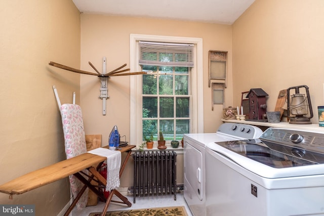 clothes washing area with independent washer and dryer, radiator, and light tile patterned floors