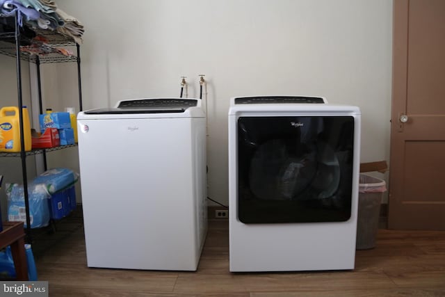 washroom with hardwood / wood-style flooring and washer and dryer