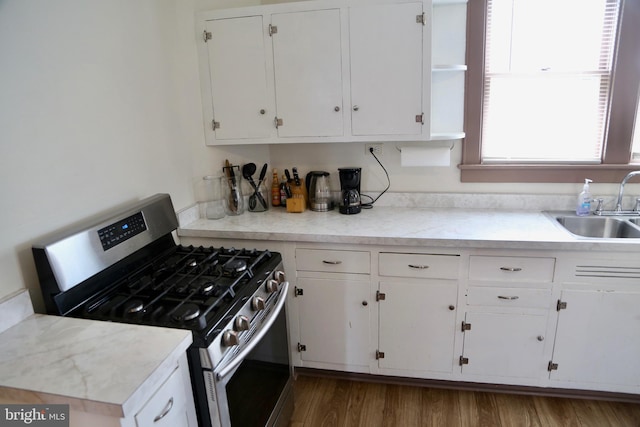 kitchen featuring sink, stainless steel range with gas cooktop, white cabinetry, and dark hardwood / wood-style floors