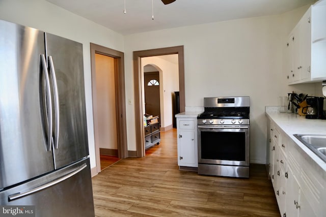 kitchen featuring appliances with stainless steel finishes, white cabinets, and hardwood / wood-style floors