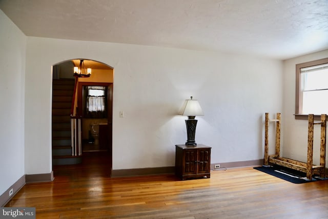 empty room featuring hardwood / wood-style floors and an inviting chandelier