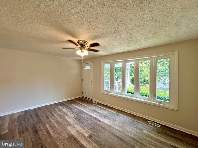 unfurnished room featuring a wealth of natural light and hardwood / wood-style flooring