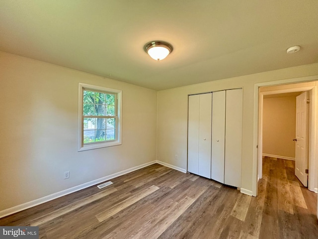 unfurnished bedroom featuring hardwood / wood-style floors and a closet