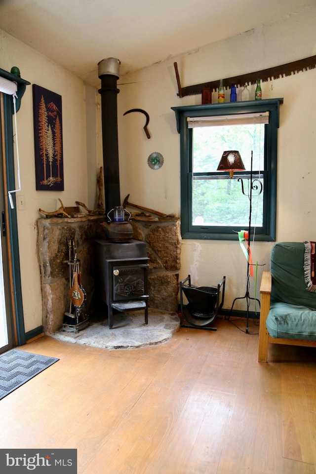 sitting room featuring hardwood / wood-style flooring and a wood stove