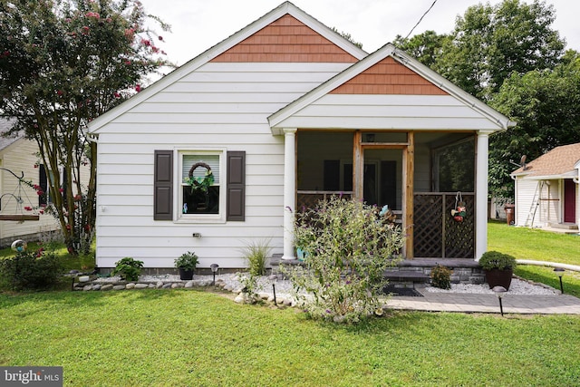 bungalow featuring a front yard and a sunroom