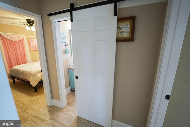 corridor featuring light hardwood / wood-style flooring and a barn door