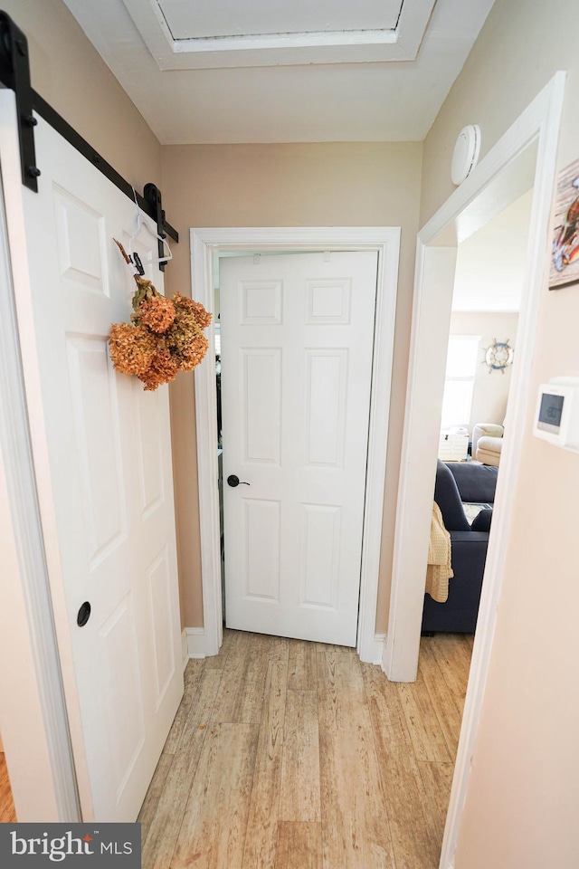 doorway featuring light wood finished floors and baseboards