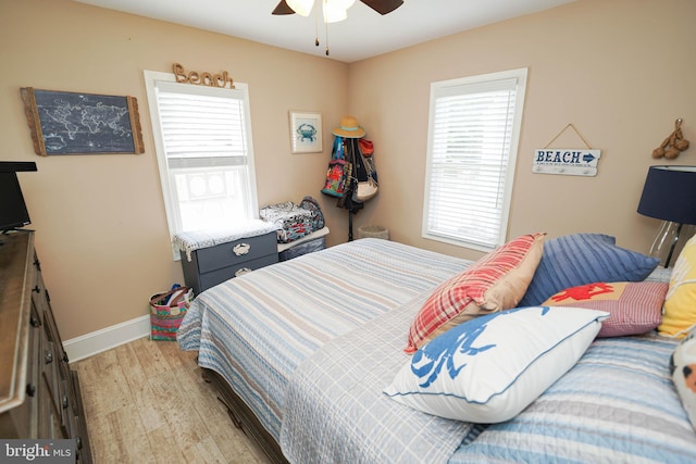 bedroom featuring ceiling fan, light wood-style flooring, and baseboards