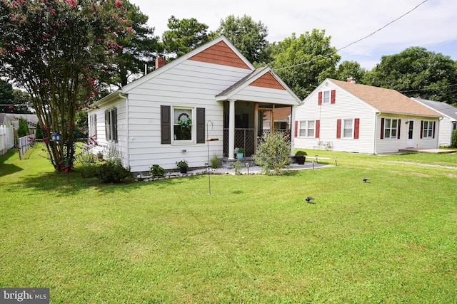 bungalow-style house featuring fence and a front yard