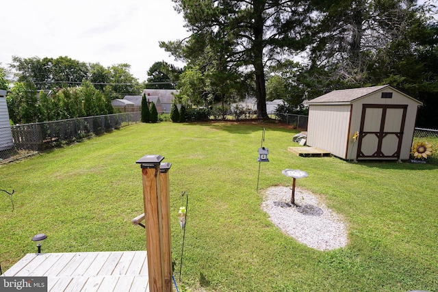 view of yard featuring a shed, an outdoor structure, and a fenced backyard