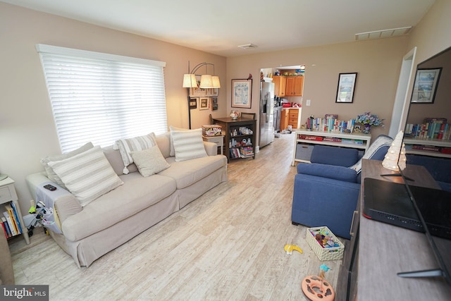 living room featuring light wood finished floors and visible vents