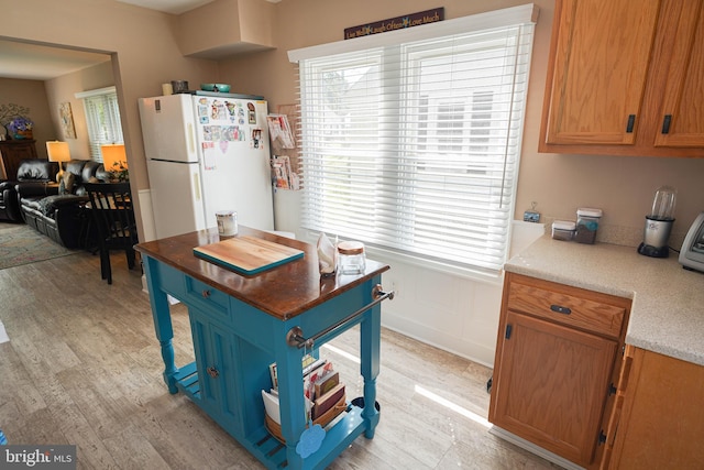 kitchen with white refrigerator and light hardwood / wood-style floors