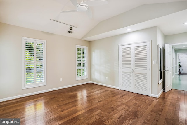 unfurnished bedroom featuring lofted ceiling, a closet, ceiling fan, and dark hardwood / wood-style floors