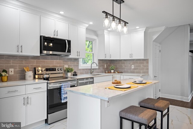 kitchen with light tile patterned floors, a center island, stainless steel appliances, light stone countertops, and decorative light fixtures