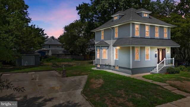 property exterior at dusk featuring a shed, a patio, and a yard