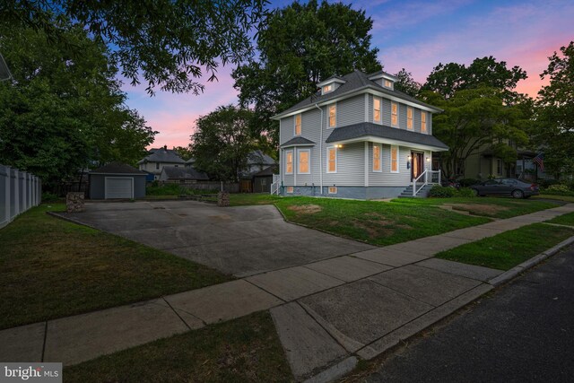 view of side of home featuring a yard and a storage unit