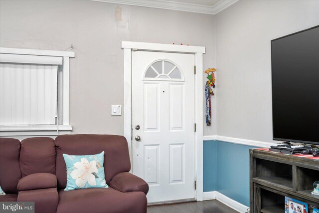 entryway with ornamental molding and hardwood / wood-style flooring