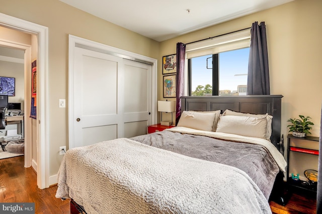 bedroom featuring dark wood-type flooring and a closet