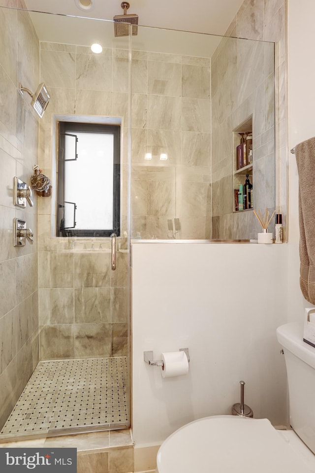 bathroom with toilet and an enclosed shower