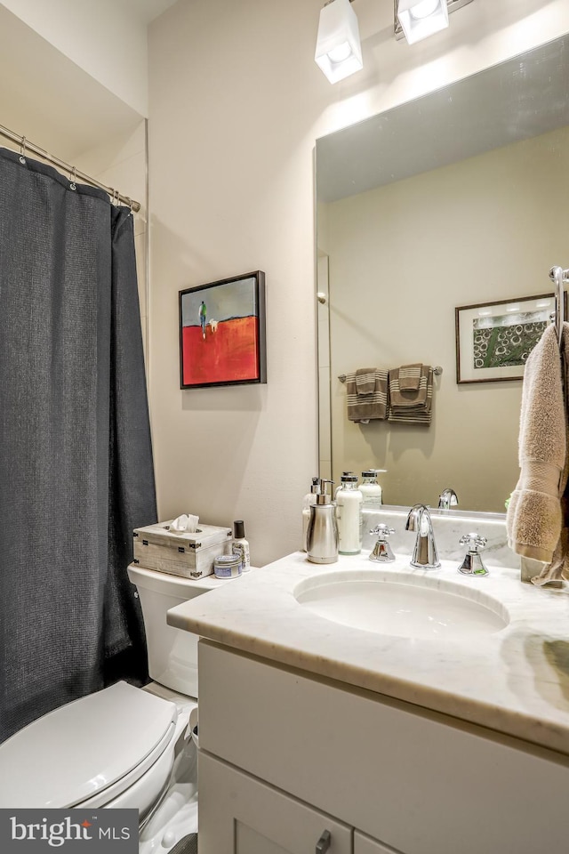 bathroom featuring a shower with curtain, vanity, and toilet