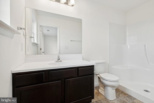 bathroom with vanity, toilet, and a shower