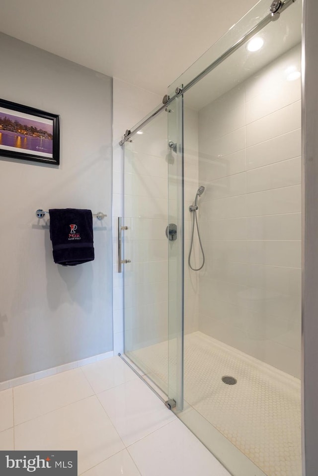 bathroom with an enclosed shower and tile patterned floors