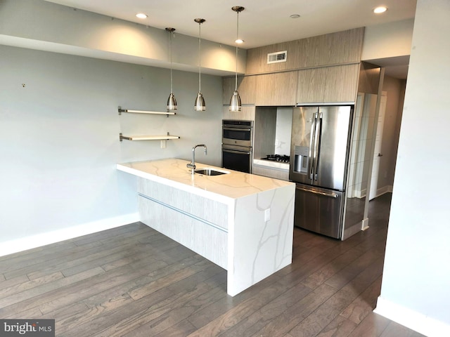 kitchen featuring stainless steel appliances, hanging light fixtures, dark hardwood / wood-style flooring, sink, and light stone counters