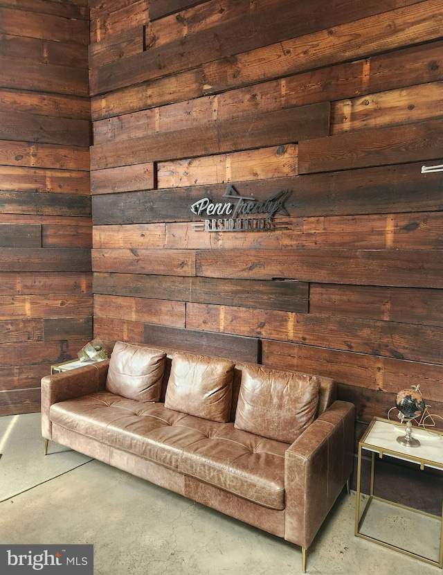 living room with wood walls and concrete flooring