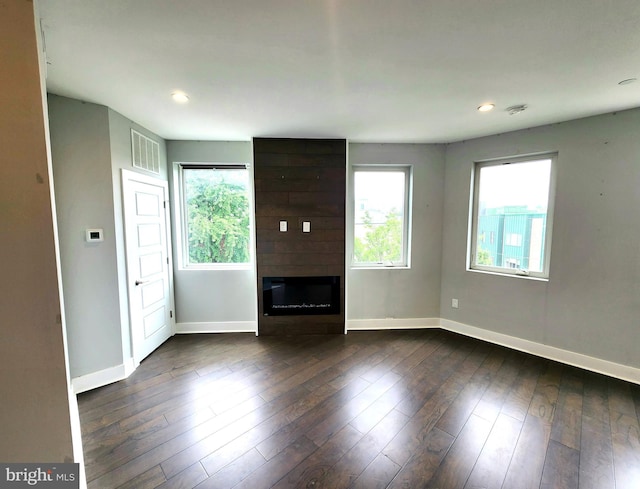 unfurnished living room featuring dark hardwood / wood-style flooring and a fireplace