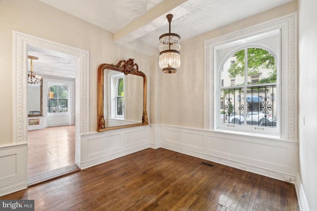 interior space featuring beamed ceiling, dark hardwood / wood-style floors, and a chandelier