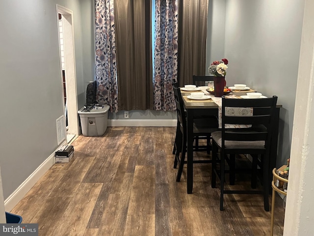 dining space with wood-type flooring