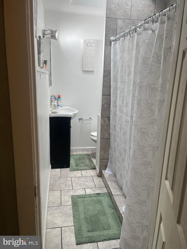 bathroom featuring tile patterned flooring, toilet, and vanity