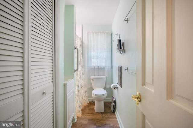 bathroom featuring wood-type flooring and toilet