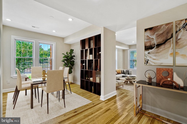 dining space featuring baseboards, plenty of natural light, visible vents, and light wood-style floors